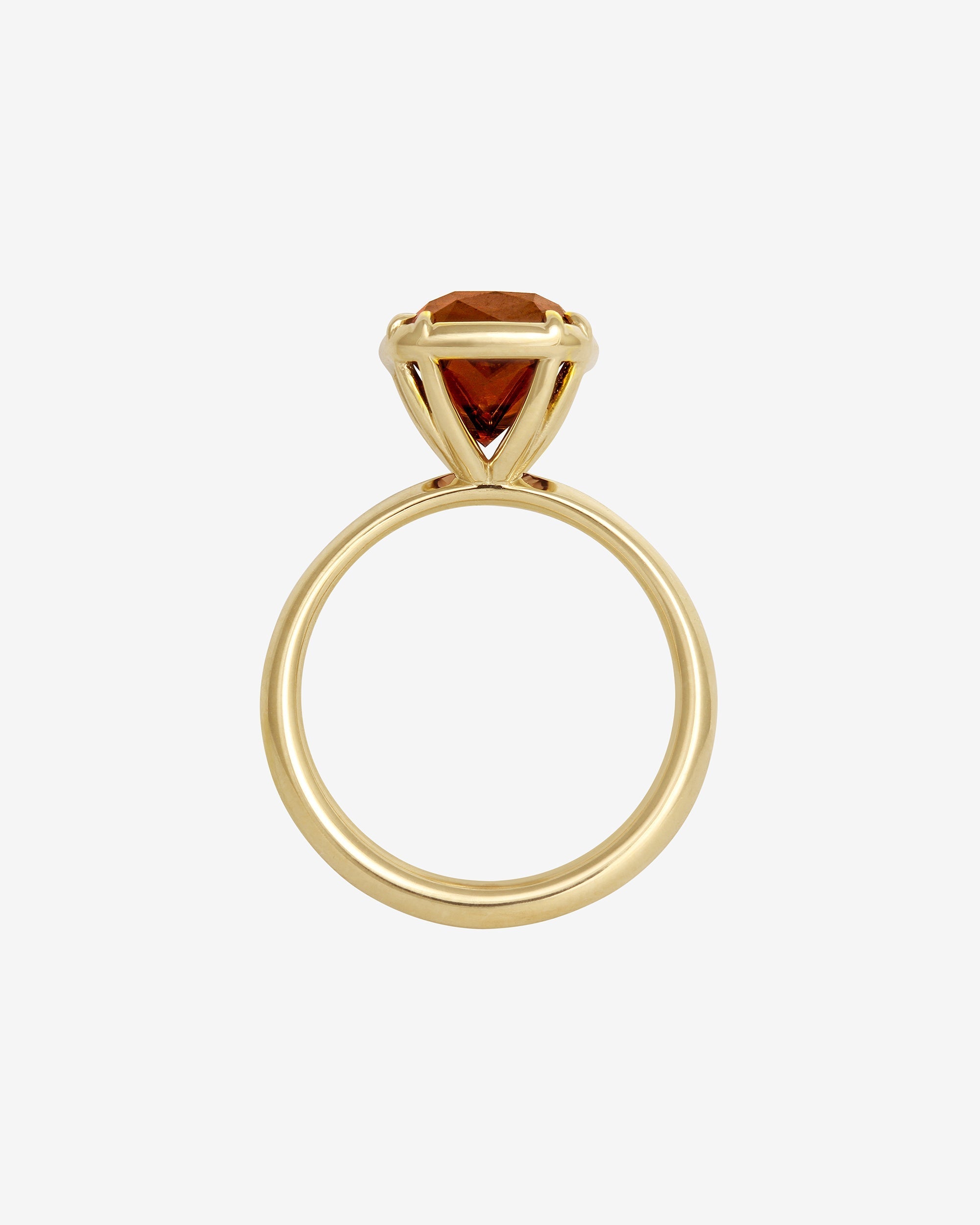 Gold ring with a red gemstone on a white background