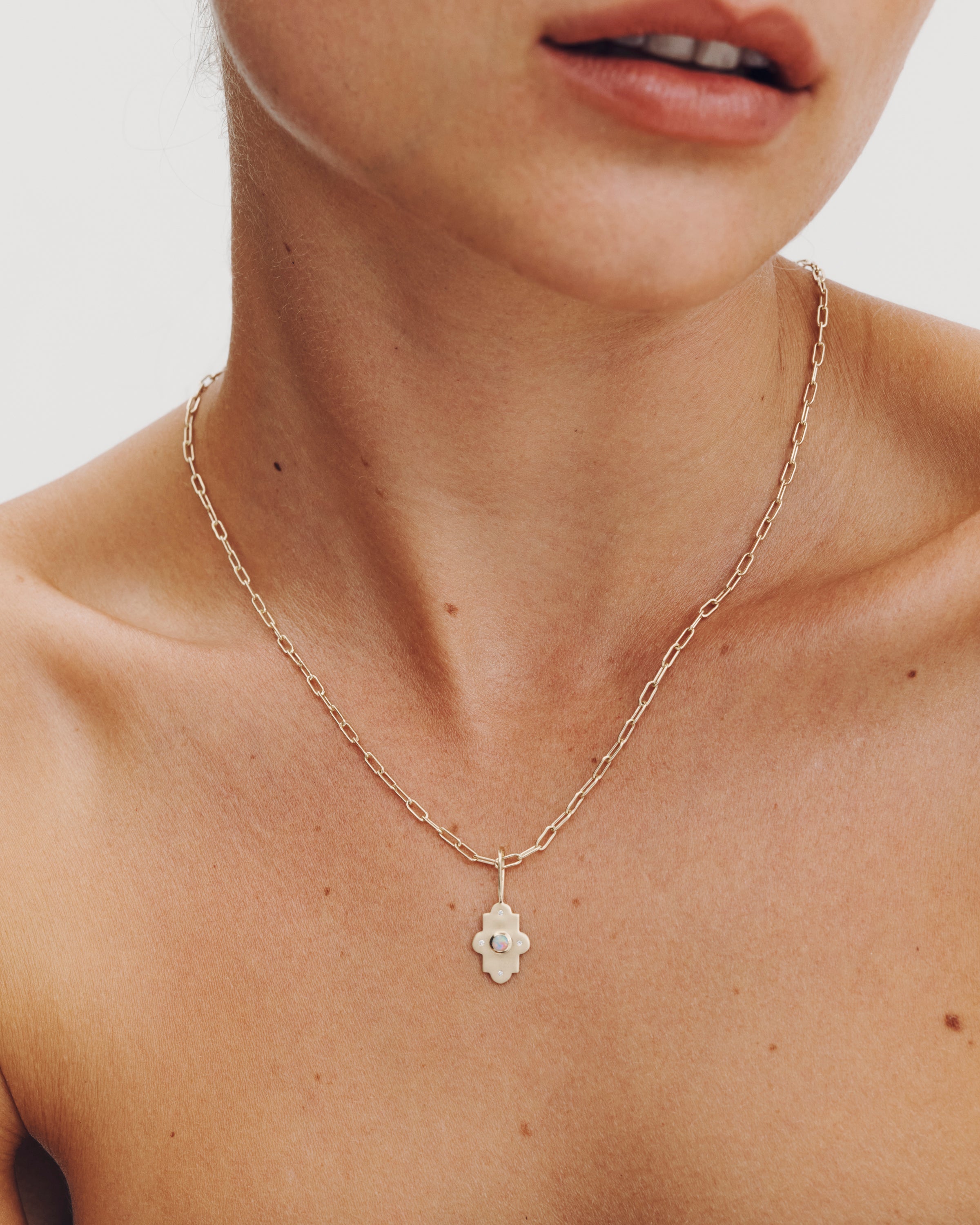 Necklace with a floral pendant worn by a person