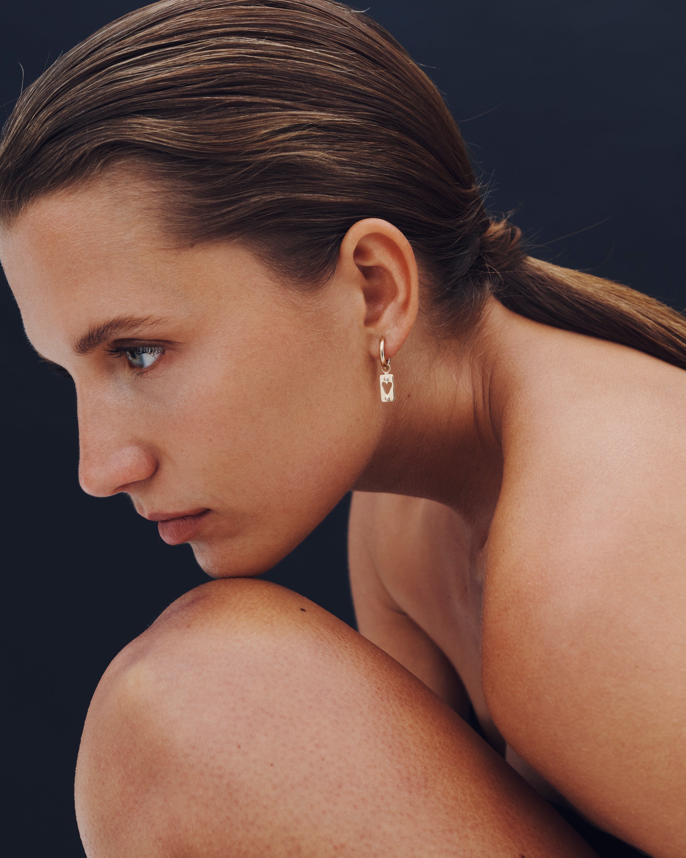 Woman with a earring on a dark background