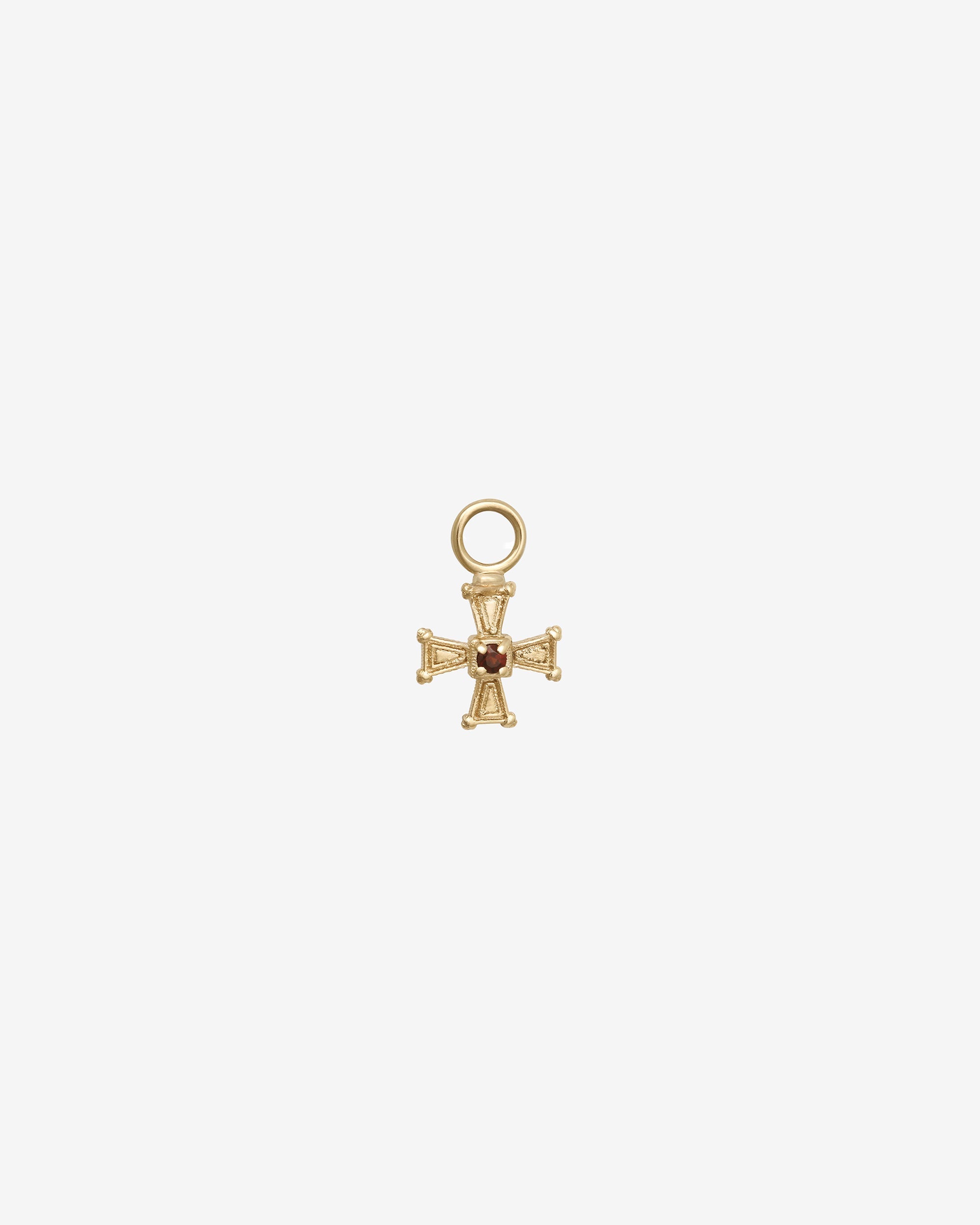 Gold cross pendant with a small gemstone on a white background
