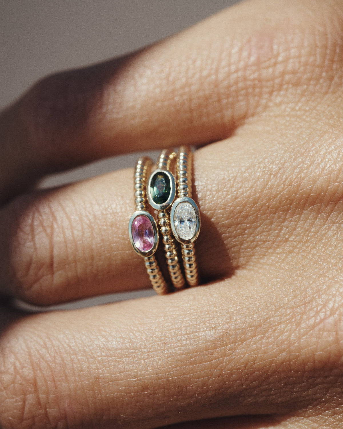Wren Pink Tourmaline, Green Tourmaline and Diamond Rings in solid gold, stacked on the hand