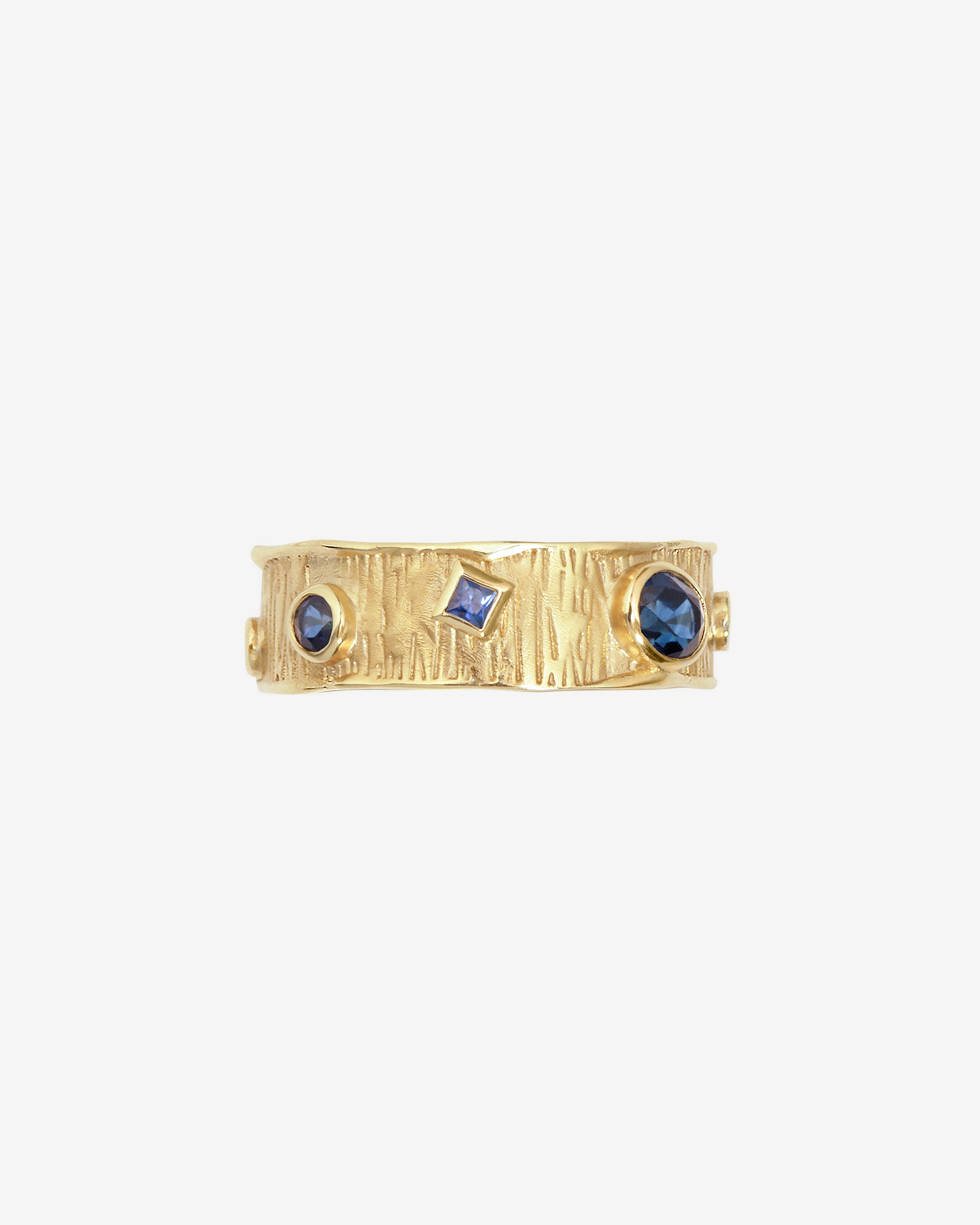 Gold ring with blue gemstones on a white background