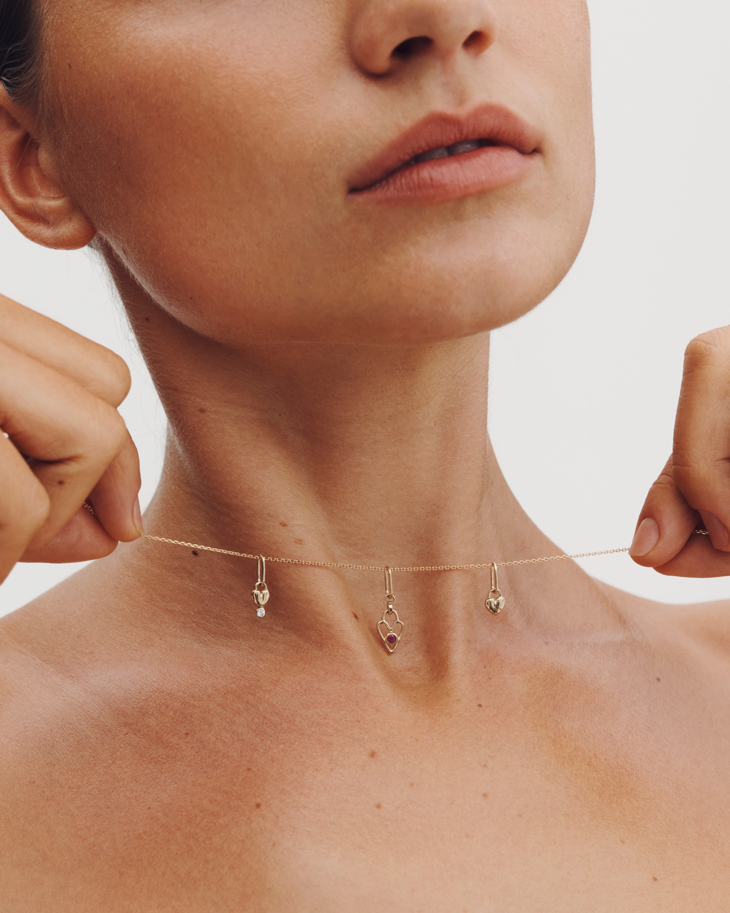 Close-up of a person wearing a delicate necklace with small pendants.