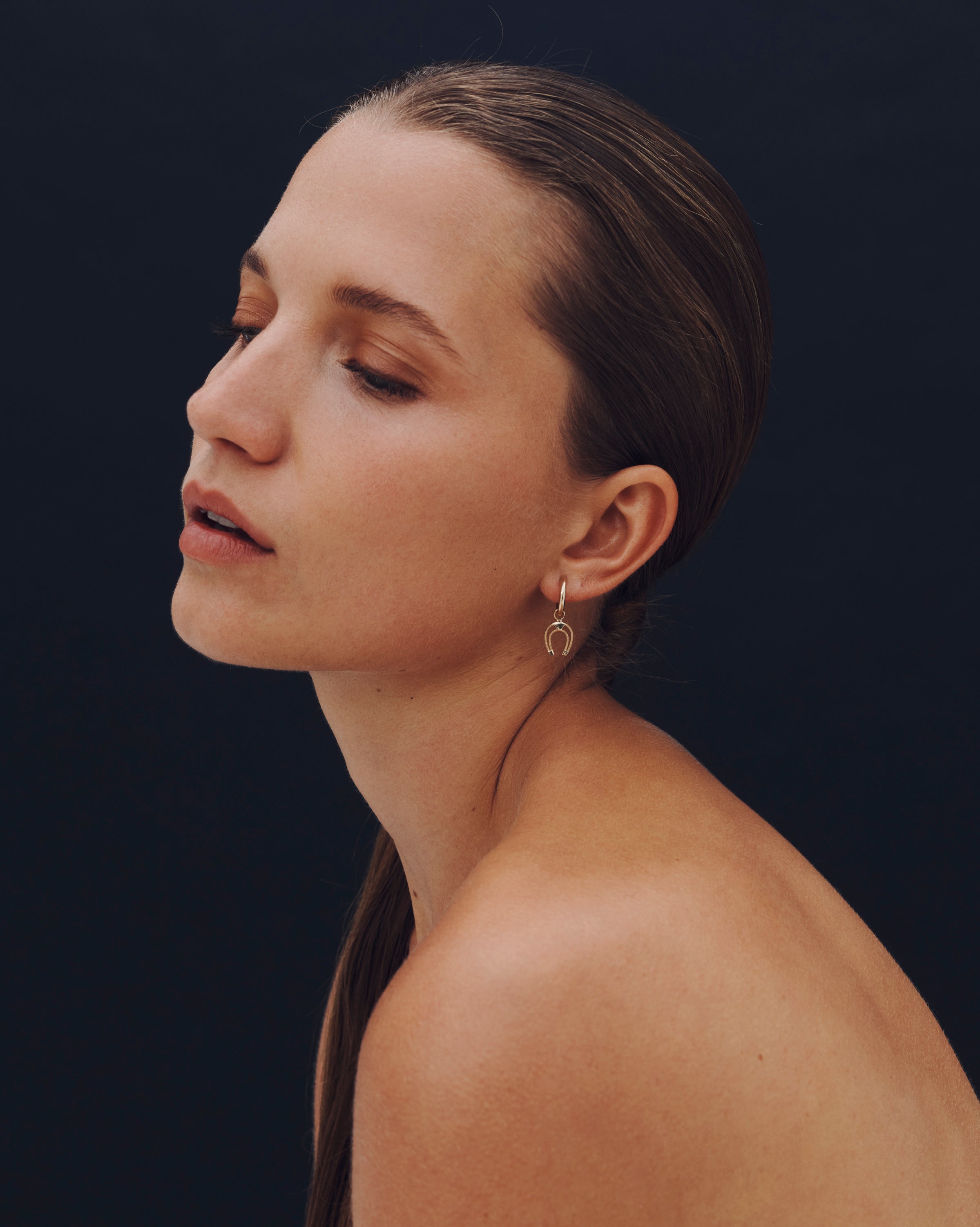 Woman with a side profile against a dark background