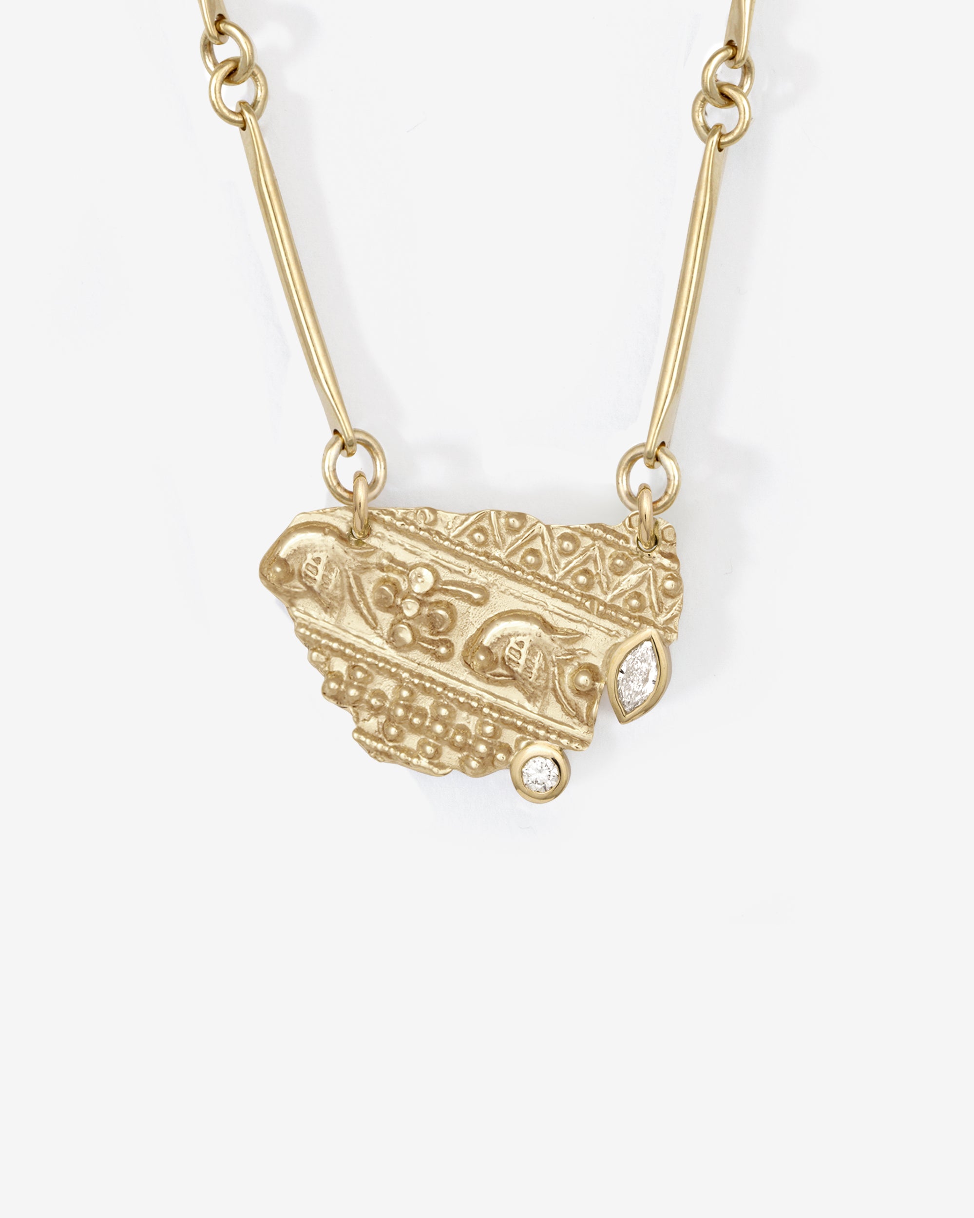 Gold necklace with an ornate pendant on a white background