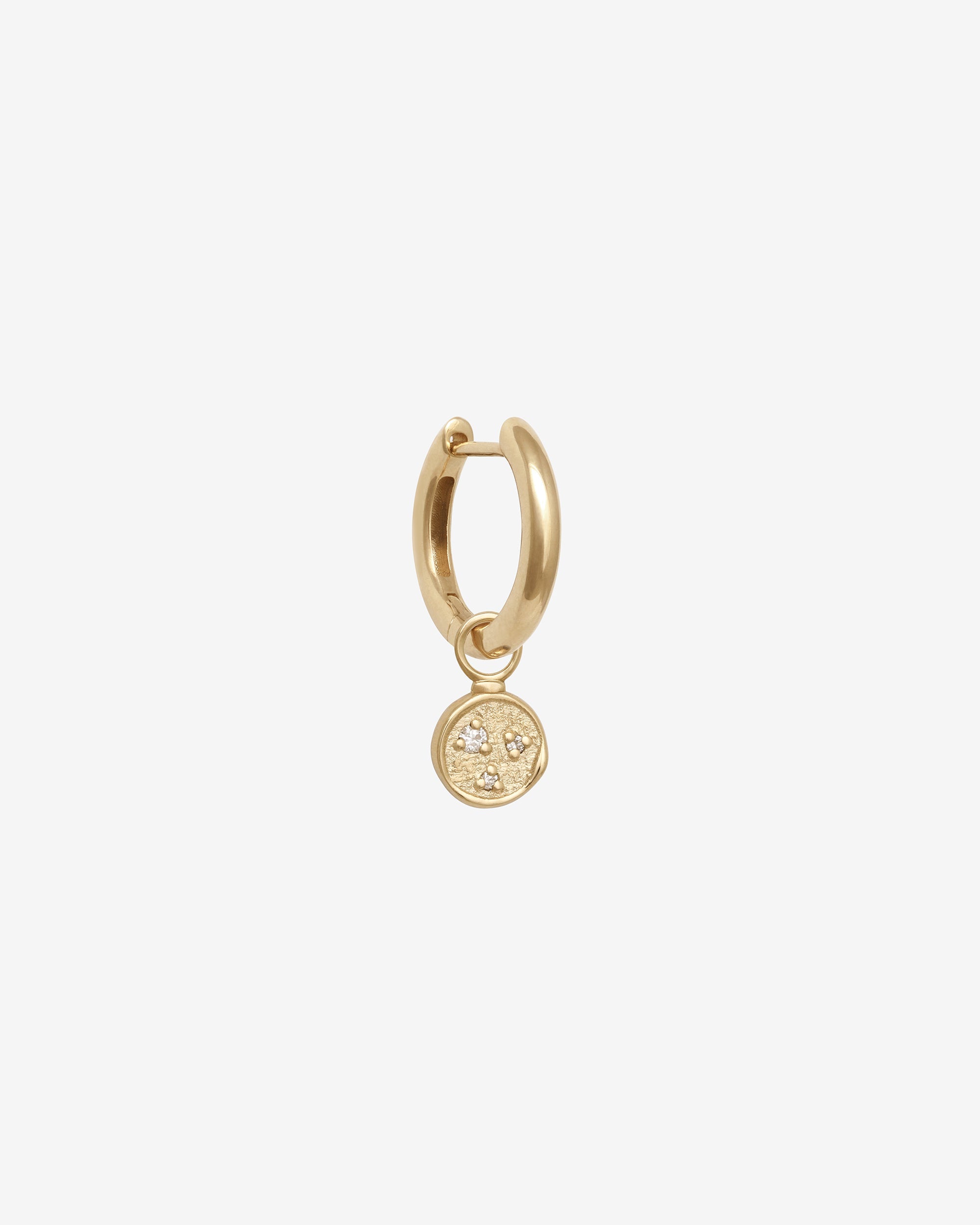 Gold hoop earring with a small round pendant on a white background