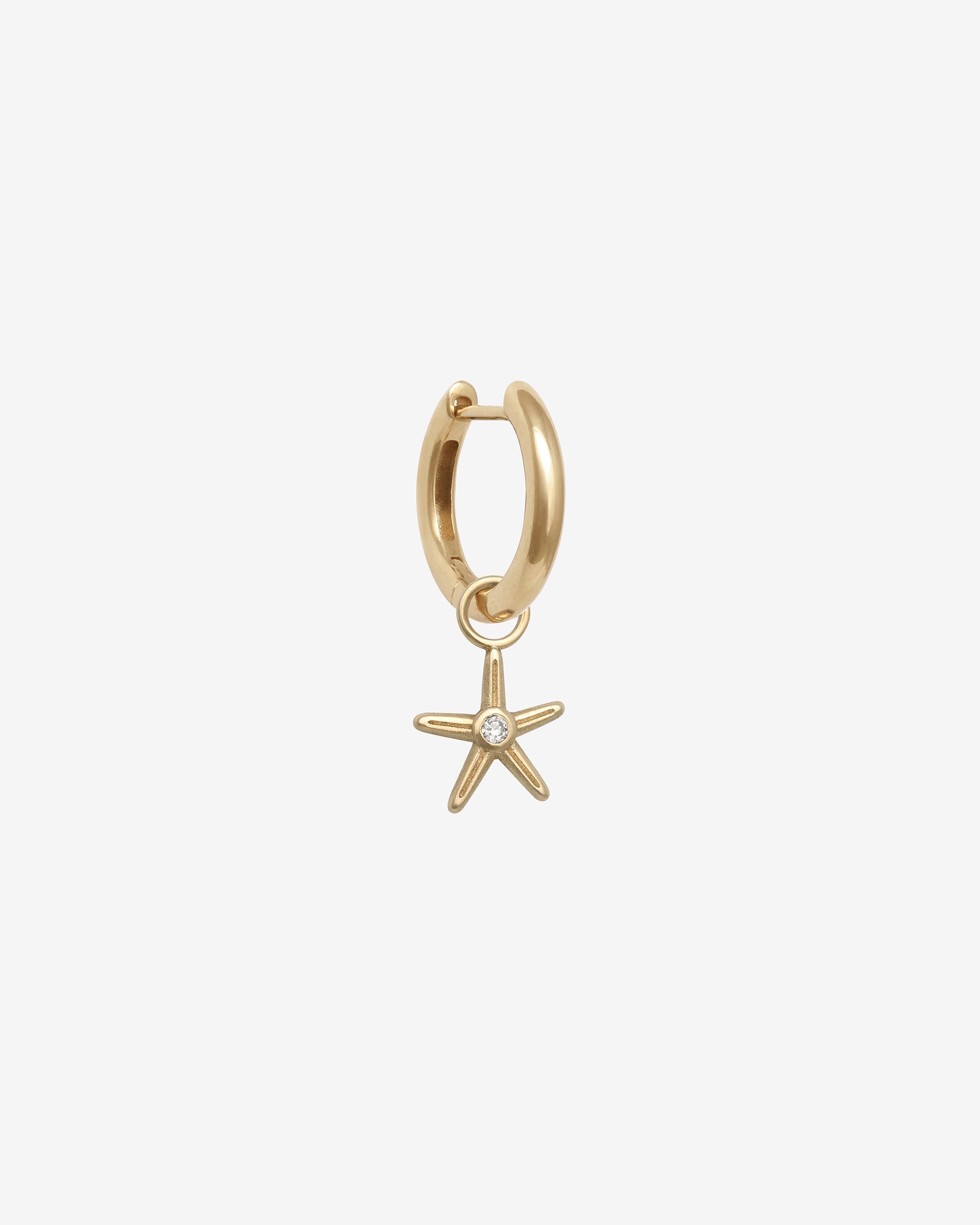 Gold hoop earring with a starfish charm on a white background