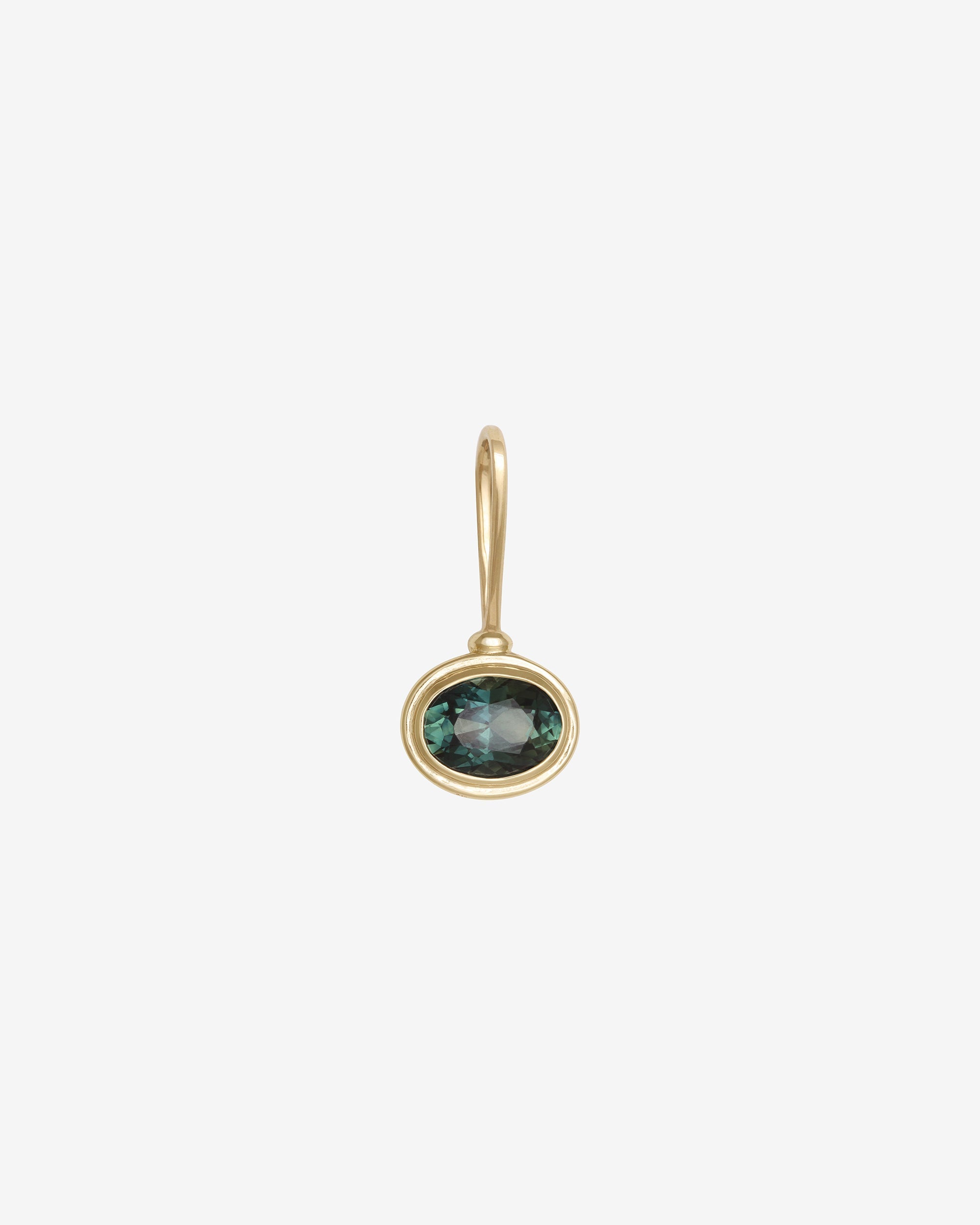Gold earring with a green gemstone on a white background